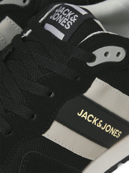 Close-up van zwarte Jack & Jones sneakers met grijze en gouden "Jack & Jones" logo.