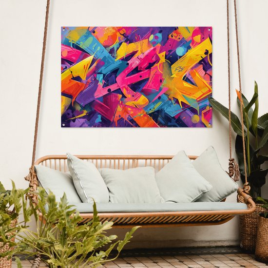 Abstracte graffiti met felle kleuren zoals roze, geel, paars en blauw, hangend aan touwen boven een rotan bank.