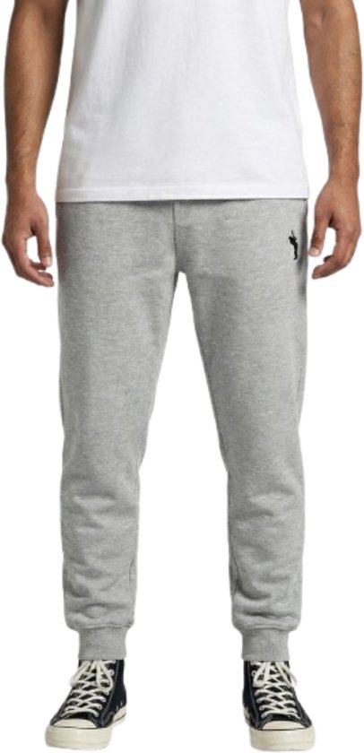 Lichtgrijze joggingbroek met zwart logo op de linkerheup, gedragen door een model.
