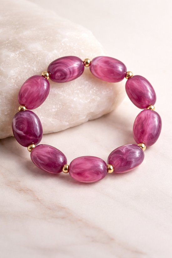 Bracelet jonc ovale violet aux motifs laiteux et aux accents dorés.
