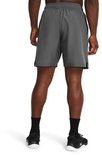 Grijze sportbroek van Under Armour met witte tekst op de zijkant, gedragen door een man.