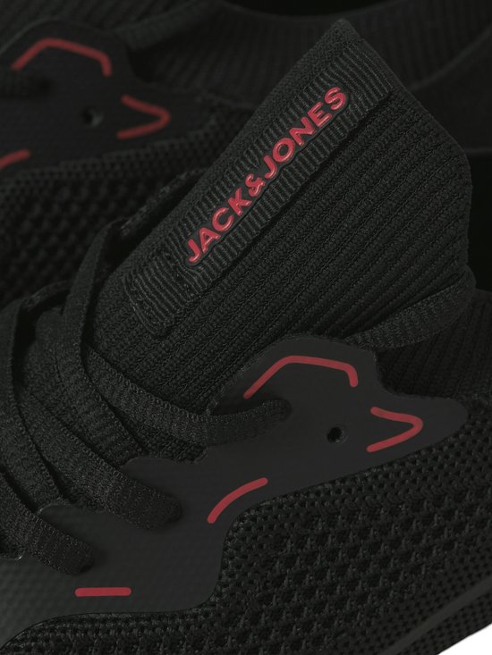 Detail van de tong van een zwarte sneaker met rode JACK & JONES tekst.