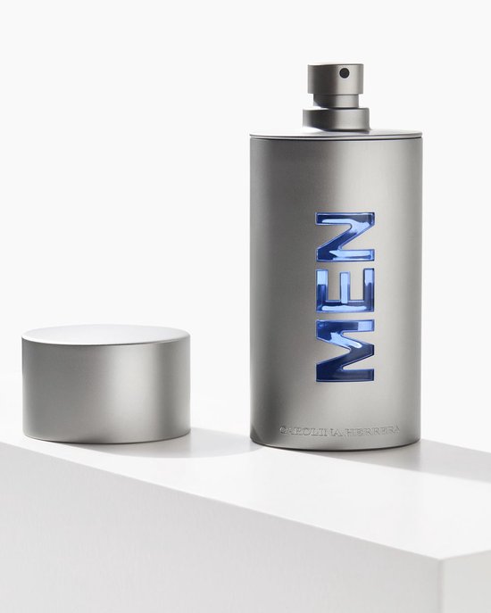 Zilverkleurige parfumfles met blauwe 'MEN' inscriptie en de dop ernaast.