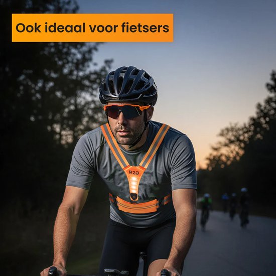 Man fietst 's avonds met oranje R2B hardloopvest met verlichting en reflecterende strepen.