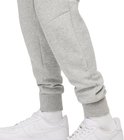 Onderlichaam van een man in een grijze Nike joggingbroek met witte sneakers.