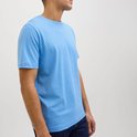 Blauwe T-shirt met ronde hals, gedragen door een man.