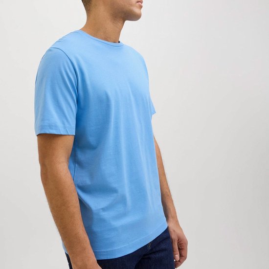 Blauwe T-shirt met ronde hals, gedragen door een man.