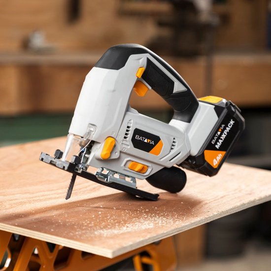 Grijze Batavia accudecoupeerzaag met 4Ah accu op houten plank, zaagblad in de plank.