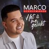 Pochette d'album de Marco Schuitmaker, "Het is me gelukt". Marco porte une veste blanche et regarde vers la droite. Salle de concert en arrière-plan.
