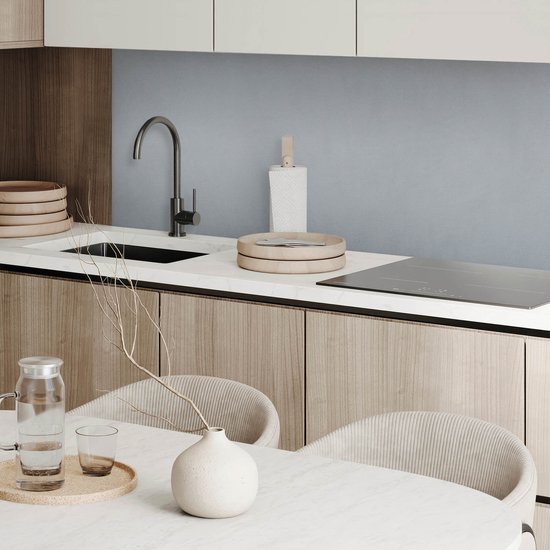 Een moderne keuken met houten kasten, marmeren aanrecht, kraan en elektrische kookplaat.