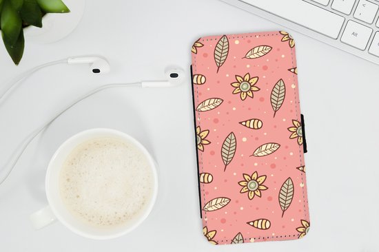 Roze telefoonhoesje met patroon van gele bloemen en beige bladeren. Magnetische sluiting zichtbaar.