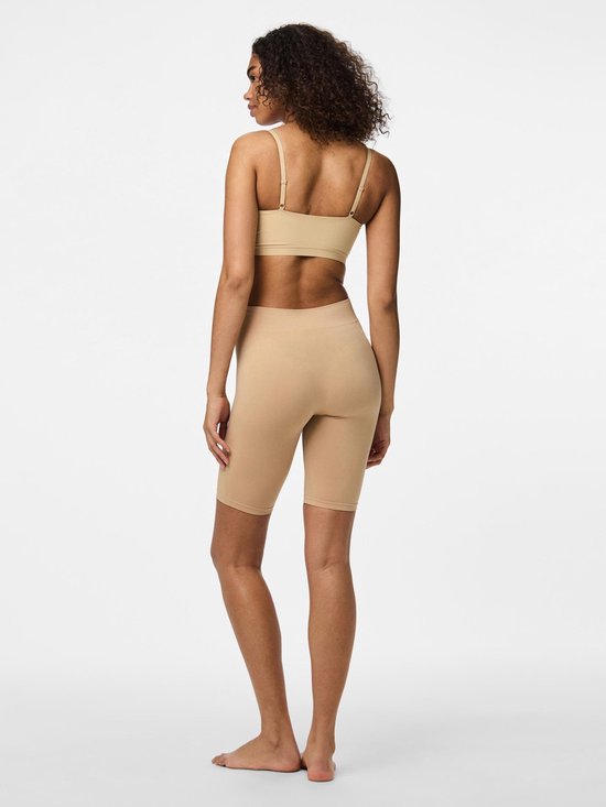 Vrouw van achteren gezien in een beige beha en beige fietsshort.