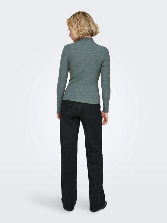 Model met blond haar draagt een grijze coltrui met lange mouwen, geribde textuur, gegolfde kraag en een zwarte broek.