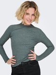 Model met blond haar draagt een grijze coltrui met lange mouwen, geribde textuur, gegolfde kraag en een zwarte broek.