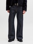 Detail van de voorkant van een donkerblauwe jeans met wijd uitlopende pijpen en gele stiksels.
