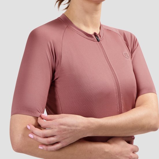 Damesfietsshirt in roze met korte mouwen, ritssluiting en subtiel reliëflogo op de borst.