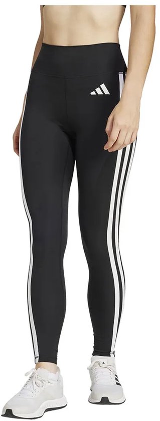 Model in zwarte legging met witte Adidas strepen op de zijkanten en witte sneakers