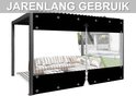 Zwarte terasscherm met rits en transparant venster, gemonteerd op een pergola met loungebank. Tekst 'JARENLANG GEBRUIK'.