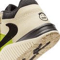 Detail van de beige sneaker met limegroene stof en geborduurde smiley.