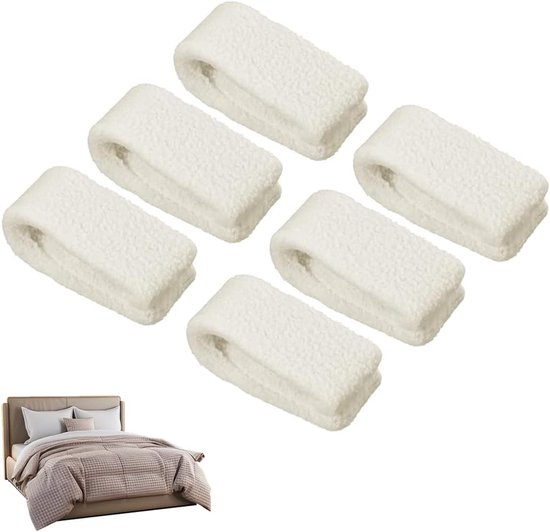 Zes witte, pluizige dekbedclips, opgesteld als een groep. Een klein bed met gedrapeerd beddengoed is zichtbaar in de hoek.