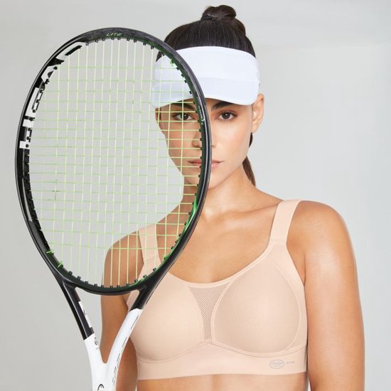Model met een tennisracket en een nude sportbeha met mesh décolleté.