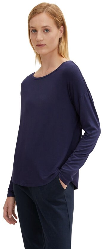 Blauw T-shirt met lange mouwen en boot hals, gedragen door een blond model.