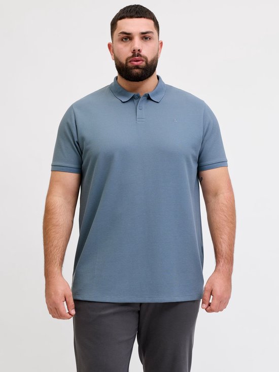 Man met baard draagt een blauw poloshirt met korte mouwen.