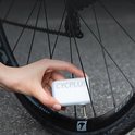 Hand houdt zwarte CYCPLUS mini-fietspomp bij een fietsventiel.
