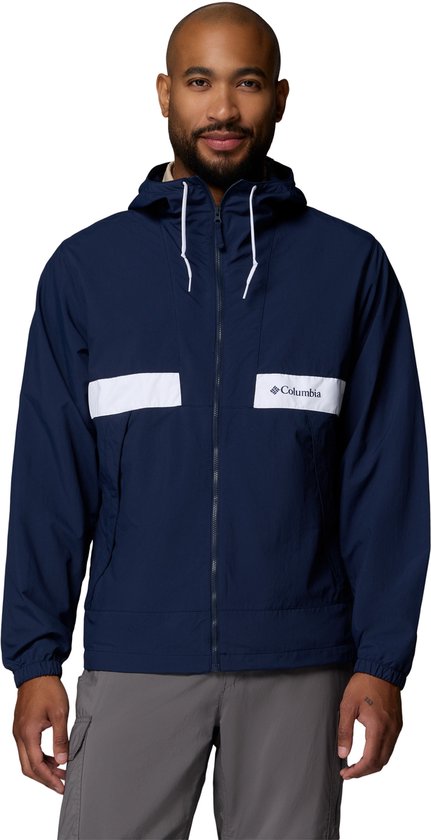 Homme portant une veste coupe-vent Columbia bleu marine avec des bandes blanches sur la poitrine et une capuche.