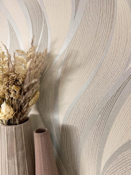 Beige en grijs behang met golvend patroon. Metallic lijnen met 3D-structuur. Vaas met droogbloemen.