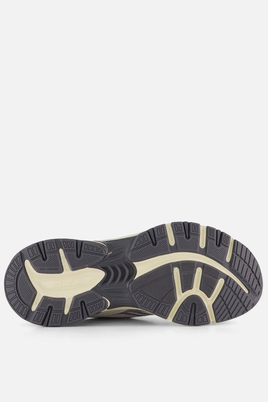 Onderkant van een grijze sneaker met profiel.