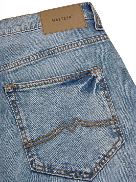 Close-up van de achterzak van een lichtblauwe Mustang jeans met bruin leren label.