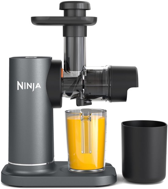 Grijze Ninja slowjuicer met zwarte details, met een glas vers geperst sinaasappelsap.