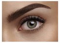 Close-up van een groen oog met lange, volle zwarte wimpers en volle wenkbrauwen.