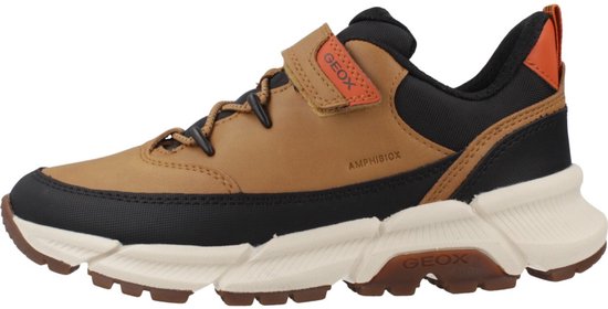 Bruine sneaker met zwarte accenten, oranje lus en klittenbandsluiting.