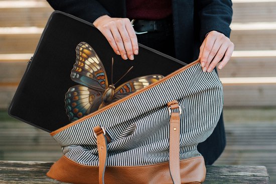 Een vrouw legt een laptop sleeve met kleurrijke vlinderprint in een gestreepte tas met bruine accenten.