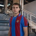 Jonge man met een FC Barcelona shirt met verticale blauwe en bordeauxrode banen, staand op een trap