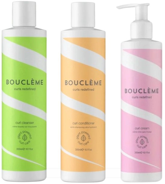 Drie Bouclème flessen: groen voor curl cleanser, oranje voor curl conditioner, roze voor curl cream. Allen met witte dop en gestreepte patronen.