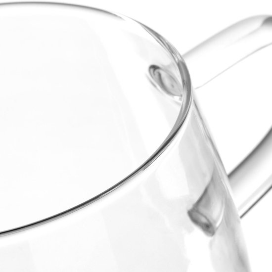 Helder glazen theeglas met een gebogen handvat, dichtbij gefotografeerd.