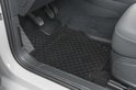 Zwarte, antislip automat met honingraatpatroon op de bestuurdersplaats van een auto.