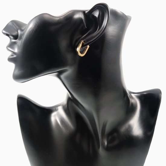 Gouden U-vormige oorbel gedragen op een zwarte mannequin.
