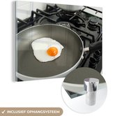 MuchoWow® Glasschilderij 60x40 cm - Schilderij acrylglas - Een gebakken ei in een pan op het fornuis - Foto op glas - Schilderijen