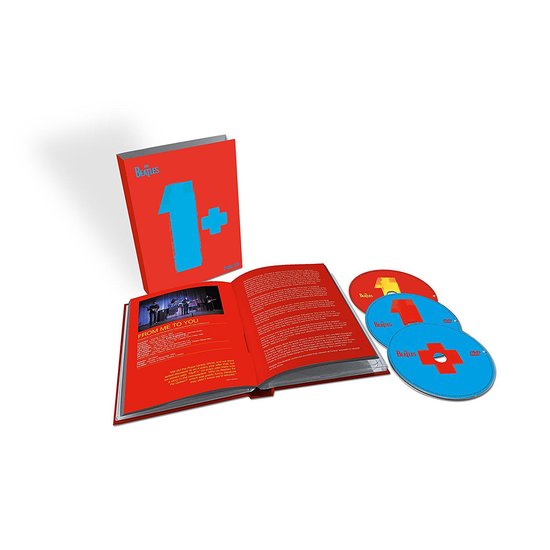 The Beatles 1+ Deluxe Edition: opengeslagen boek met foto en tekst, 3 cd's en een boekje.