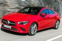 Rode Mercedes-Benz CLA Coupé met zwart dak, in beweging op een weg.