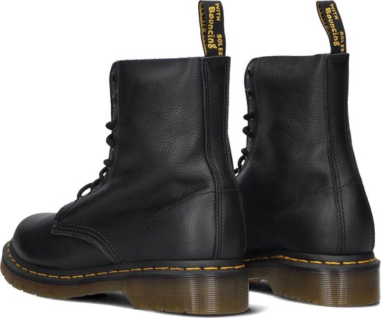 Arrière de deux bottes à lacets Dr. Martens Pascal noires en cuir grainé, avec surpiqûres jaunes.