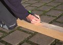 Een man markeert een houten balk met een groene Pica BIG DRY stift.