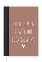 Notitieboek - Schrijfboek - Engelse quote "I love it when i catch you looking at me" op een bruine achtergrond - Notitieboekje klein - A5 formaat - Schrijfblok