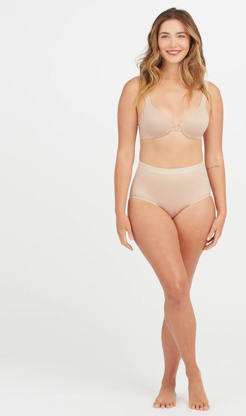 Nude hoge bikinislip met textuur en verstevigende inzetstukken. Gedragen door een model.