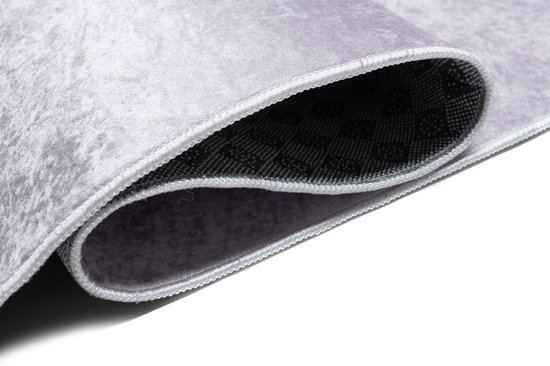 Rouleau détaillé d'un tapis rose avec dessous antidérapant.