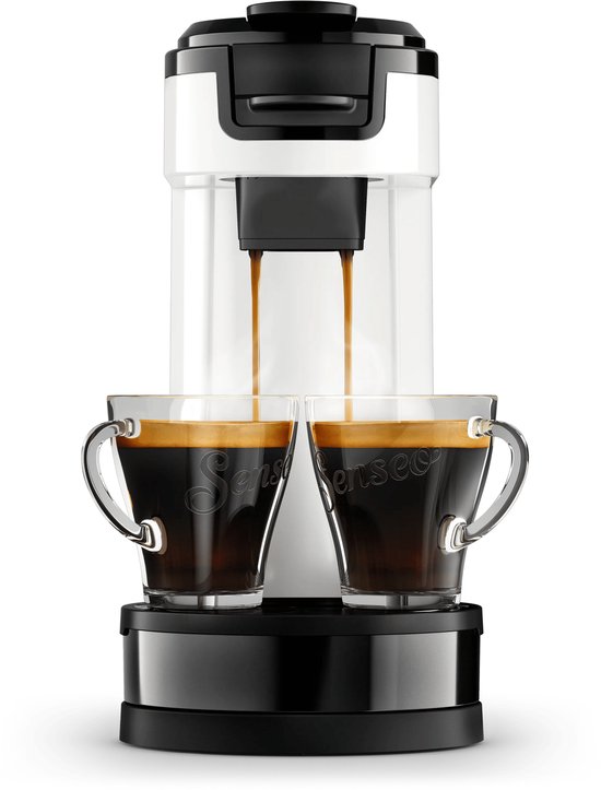 Wit Senseo koffiezetapparaat dat koffie schenkt in twee glazen kopjes, met een zwarte basis.